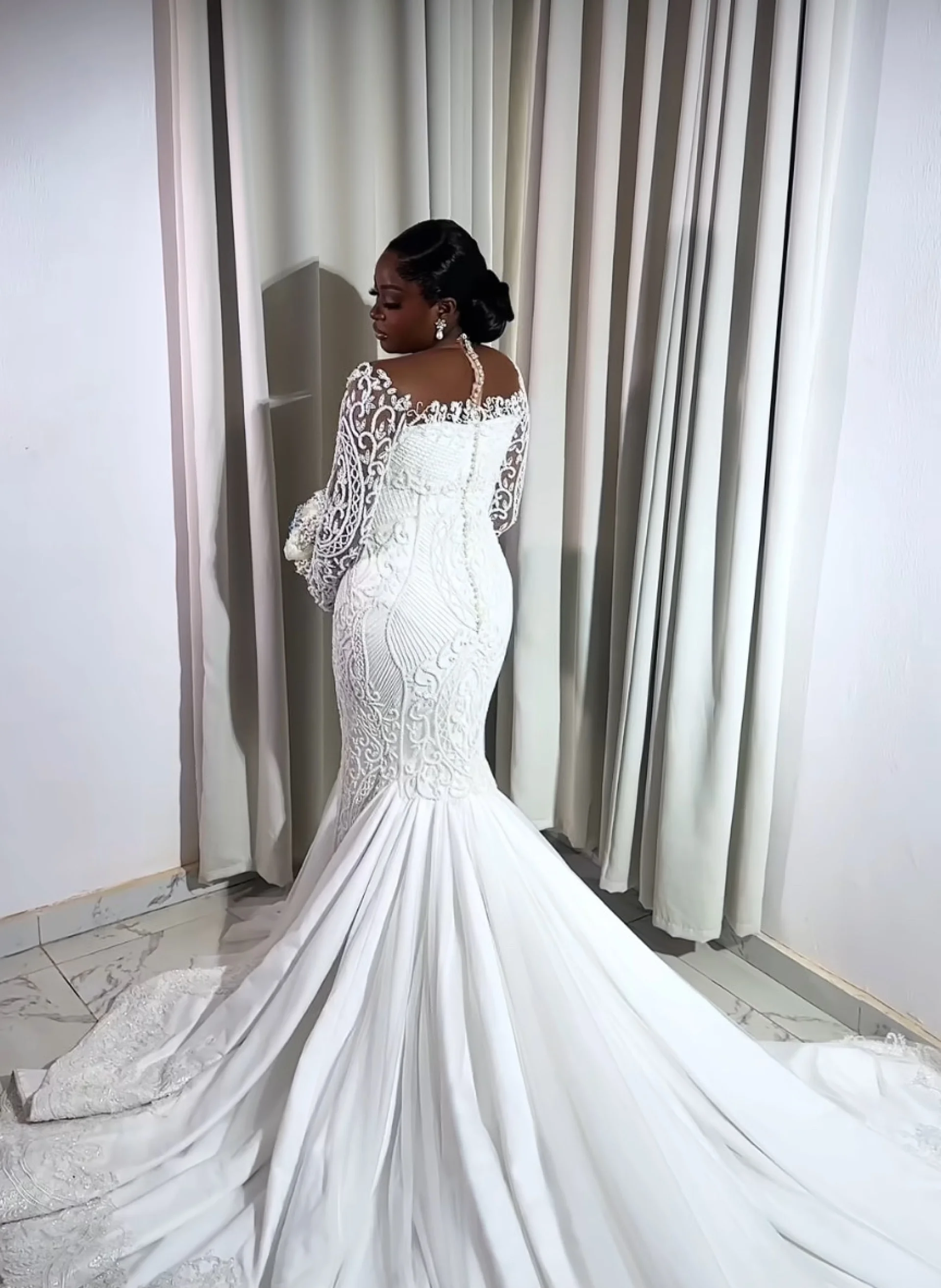 Back detail of a beaded lace mermaid gown with sheer sleeves