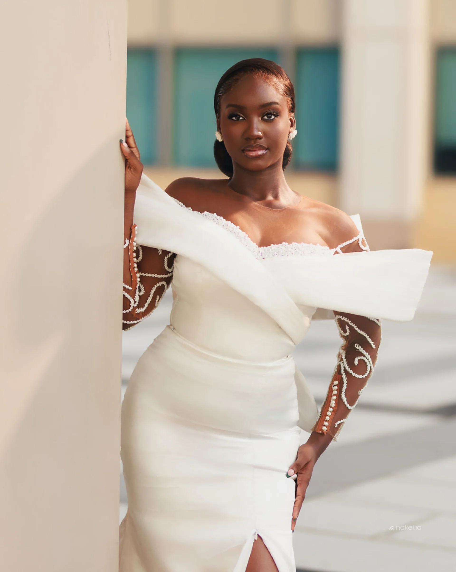 Bride in a structured white gown with an origami-fold shoulder wrap