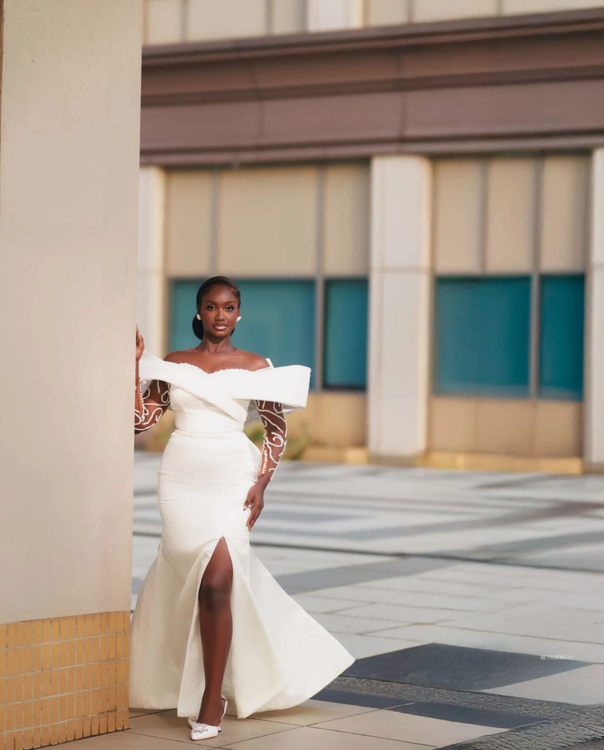 Bride in an off-white wrap-detail gown with a front slit, courtyard columns