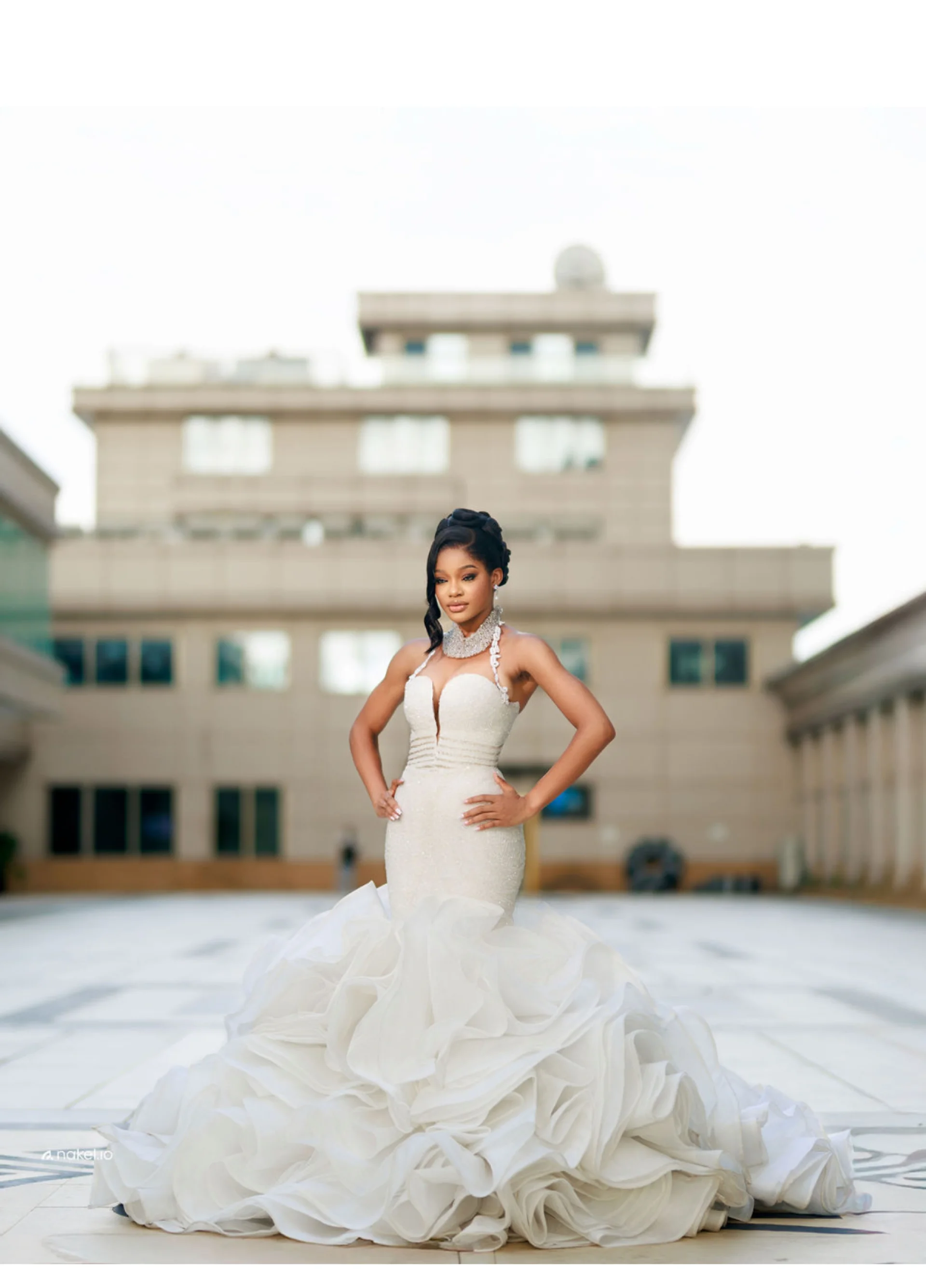 Bride in a fitted mermaid gown with a ruffled hem, courtyard setting