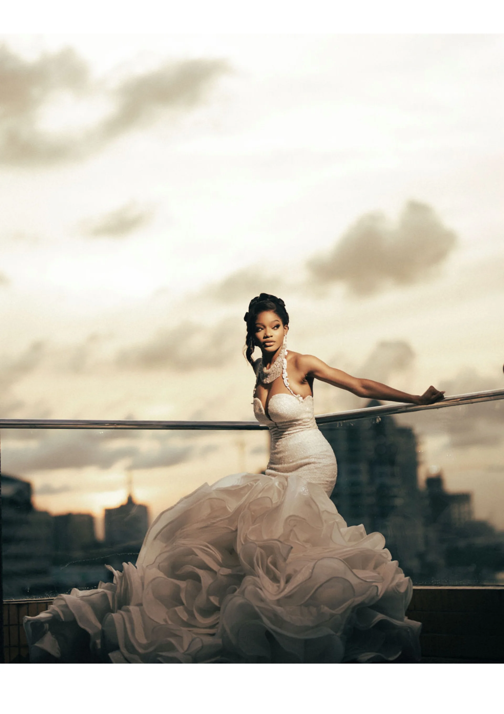 Bride in a dramatic ruffled rosette ballgown on a rooftop at dusk